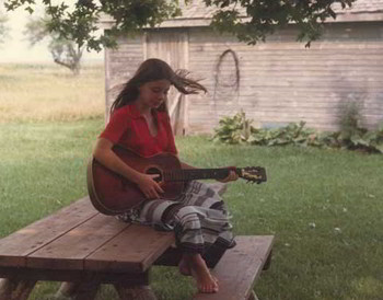 Charlotte playing guitar on the farm